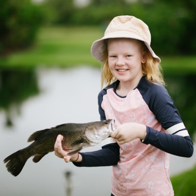 girl holding a barramundi fish